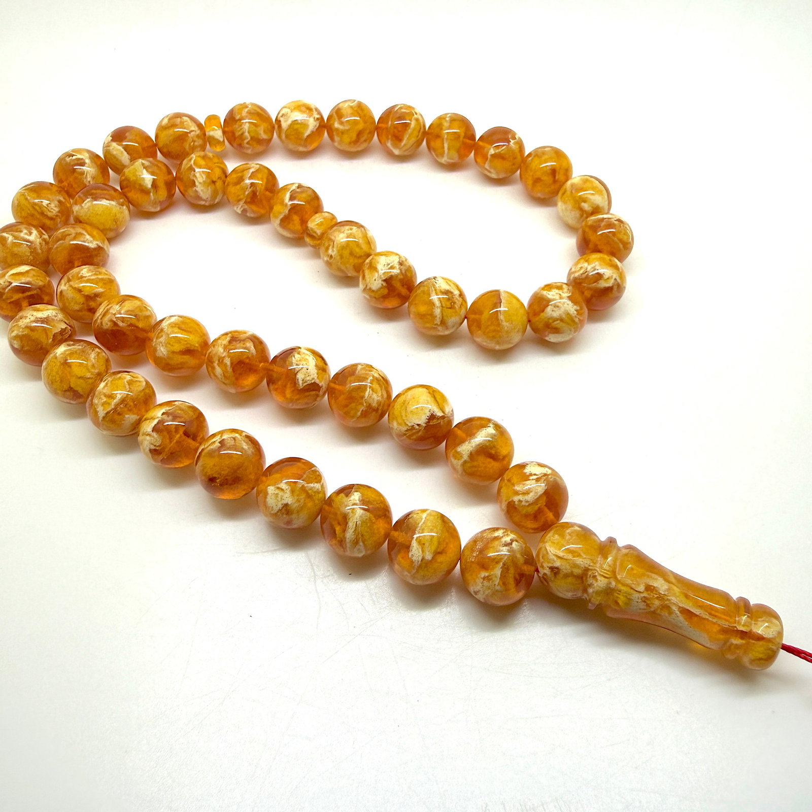 Phenomenal Amber Tesbih made from Round Amber beads: Title:Phenomenal Amber Tesbih made from Round Amber beads Metal:None Gemstone:Reconstituted Amber Weight:75.9 g Size:14mm Made of:(Reconstituted Amber or Whole Stone):Reconstituted Amber Additional