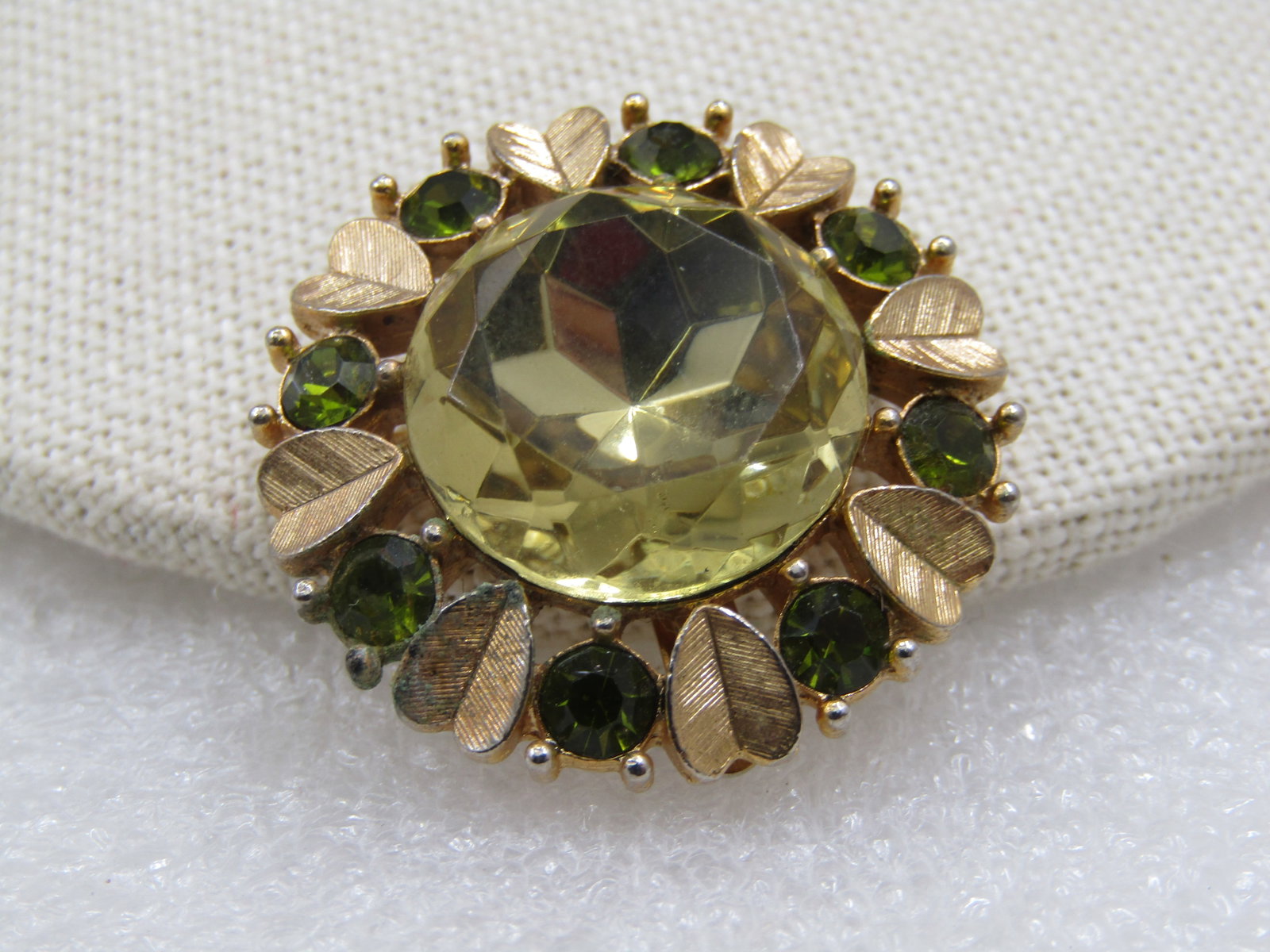 Vintage Rhinestone Green/Yellow Pendant/Brooch, Heart Leaves 1.25": Title: Vintage Rhinestone Green/Yellow Pendant/Brooch, Heart Leaves 1.25" Description: Vintage Rhinestone Green/Yellow Pendant/Brooch, Heart Leaves 1.25". Gold Tone. Avon signed. This has a center 17.