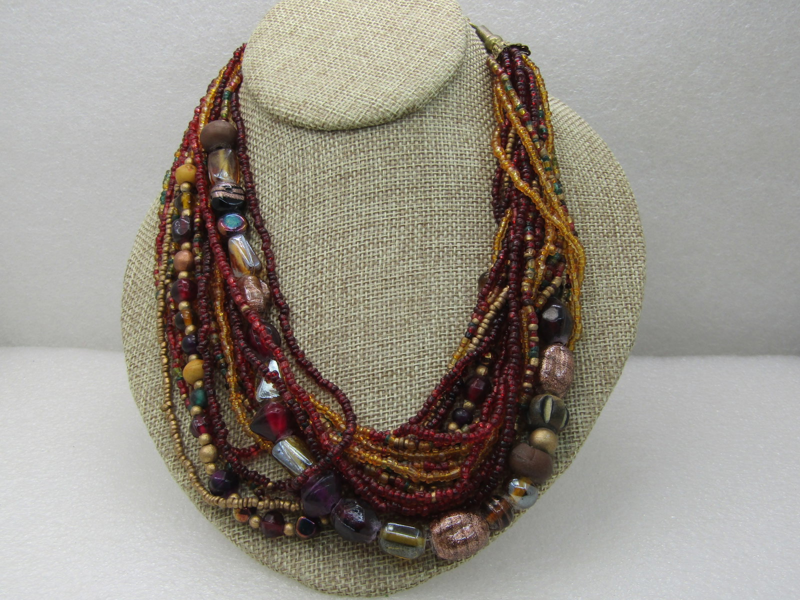 Vintage Boho Torsade Multi-Strand Necklace, Glass Beaded, 17 Strands, 21" Autumn Colors in dark red,: Title: Vintage Boho Torsade Multi-Strand Necklace, Glass Beaded, 17 Strands, 21" Autumn Colors in dark red, gold flecked, tan, gold, green, orange, yellow. A mix of mostly glass seed beads but also me