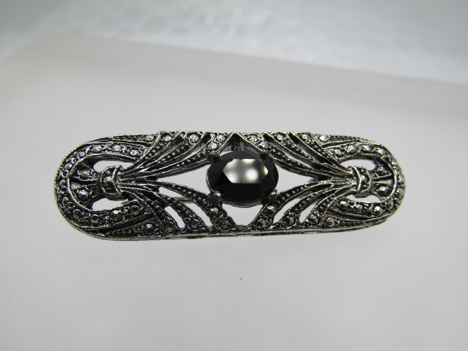 Vintage Black Glass Faux Marcasite Brooch, 1980's, 1.5": Title: Vintage Black Glass Faux Marcasite Brooch, 1980's, 1.5" Description: Vintage Black Glass Faux Marcasite Brooch, 1980's, 1.5" wide and 1/2" tall with open work on the rounded bar brooch and a bl