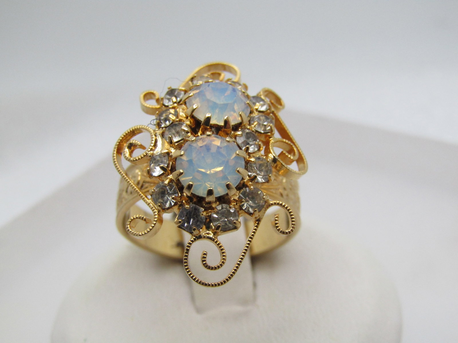 Vintage Faux Opal Rhinestone Ring, Adjustabel, 1970's-1980's: Title: Vintage Faux Opal Rhinestone Ring, Adjustabel, 1970's-1980's Description: Vintage Faux Opal Rhinestone Ring, Adjustable, 1970's-1980's. The rop has textured scrolls with two prong-set 6mm opali