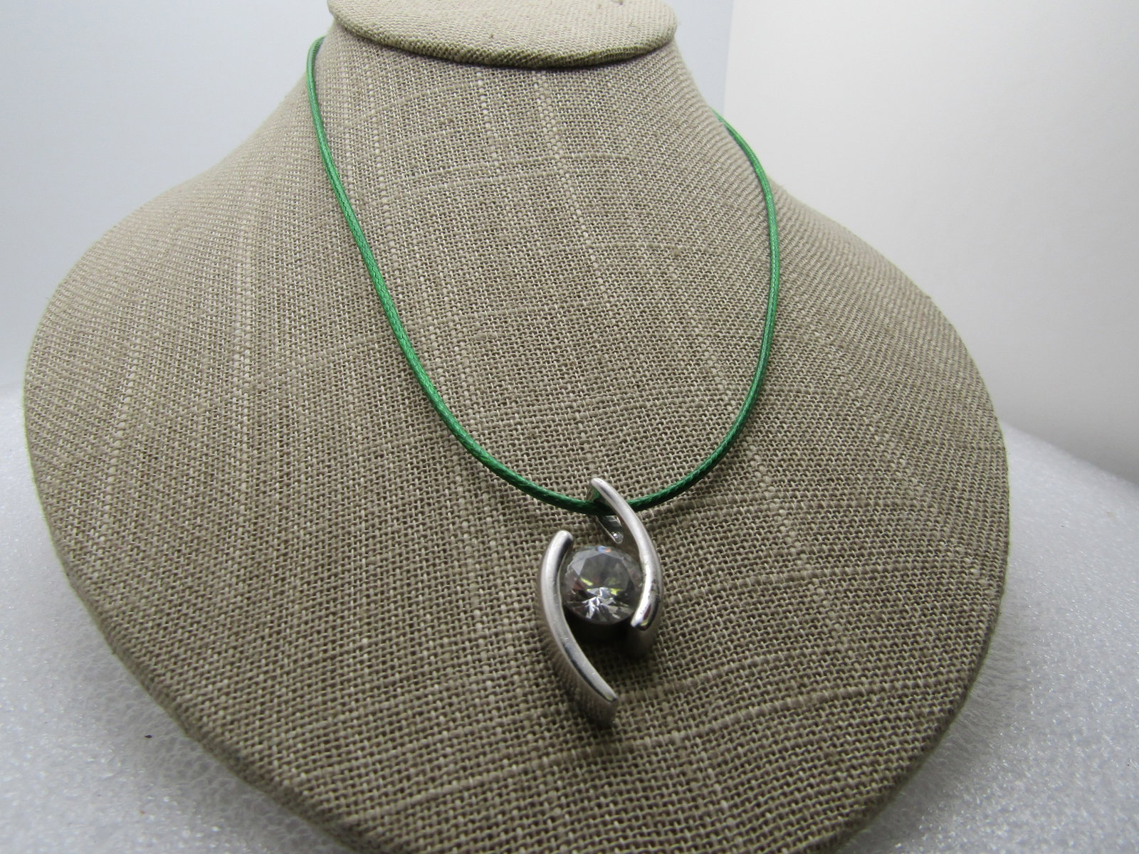 Vintage Rhinestone Bypass Pendant Necklace, 17"-19", Green Cord: Title: Vintage Rhinestone Bypass Pendant Necklace, 17"-19", Green Cord Description: Vintage Rhinestone Bypass Pendant Necklace, 17"-19", Green Cord. The pendant is silver tone with staggered length cu