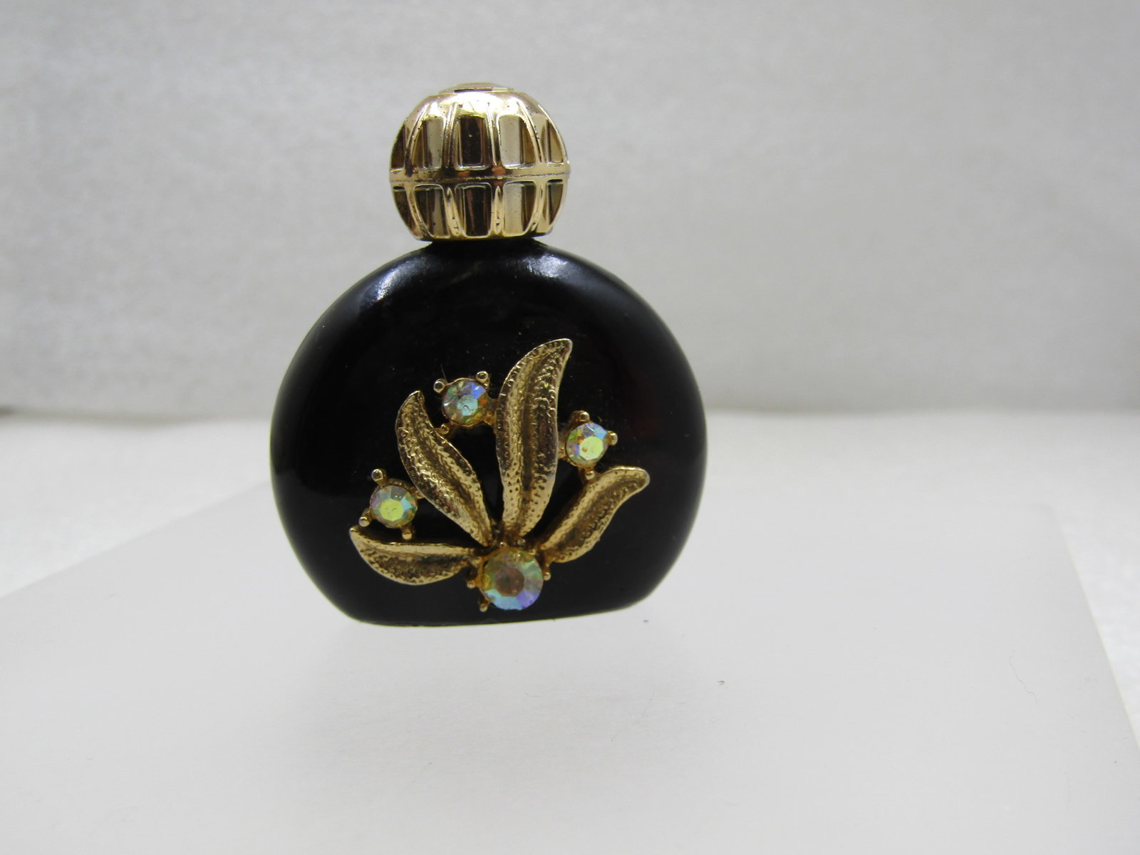 Vintage Small Black Floral Rhinestone Perfume Bottle, 1940's-1950's: Title: Vintage Small Black Floral Rhinestone Perfume Bottle, 1940's-1950's Description: Vintage Small Black Floral Rhinestone Perfume Bottle, 1940's-1950's. This has a floral/leaf gold tone accent on 