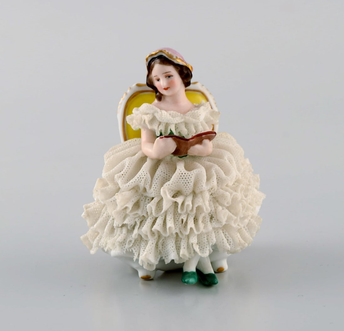 Volkstedt Rudolstadt, Germany. Porcelain figure. Reading woman in skirt. Mid-20th century.: Title: Volkstedt Rudolstadt, Germany. Porcelain figure. Reading woman in skirt. Mid-20th century. Description: Volkstedt Rudolstadt, Germany. Porcelain figure. Reading woman in skirt. Mid-20th century