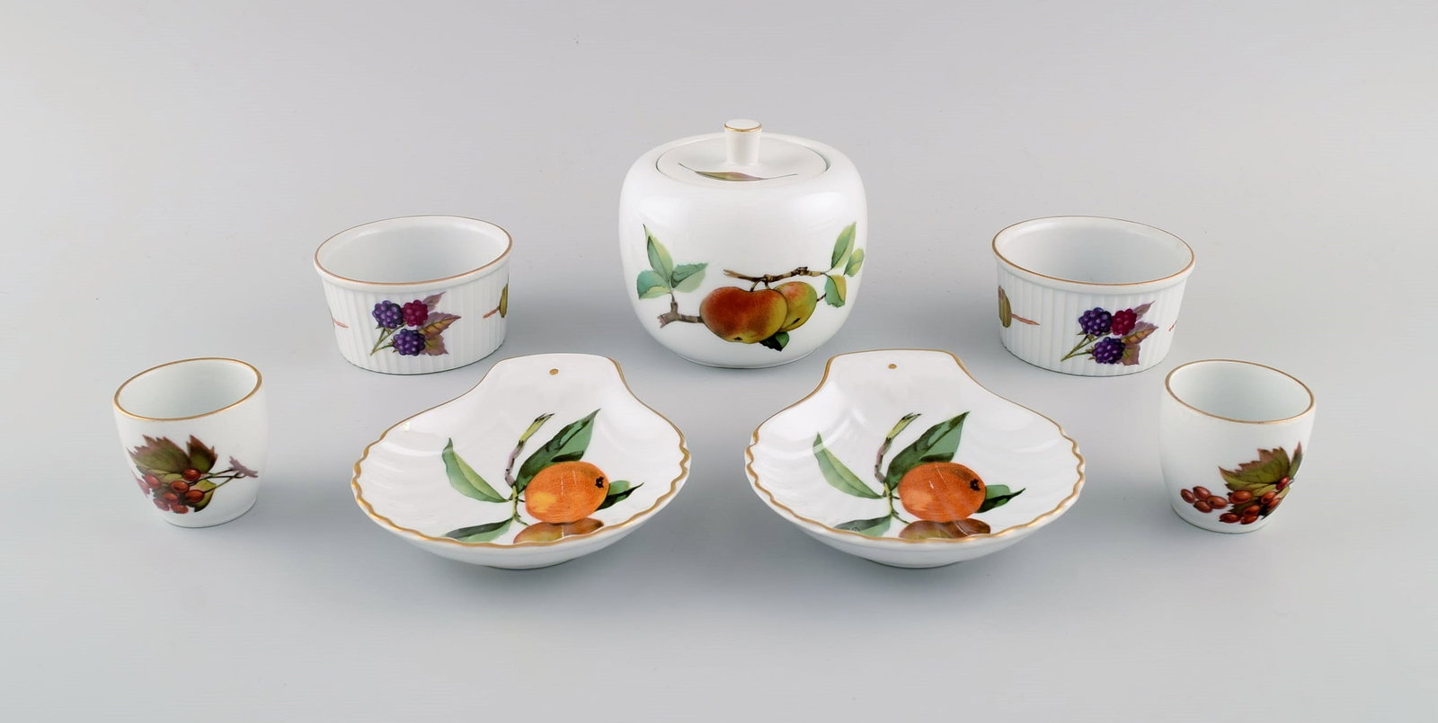 Royal Worcester, England. Seven pieces of Evesham porcelain decorated with fruits and gold edge. (1 of 8)
