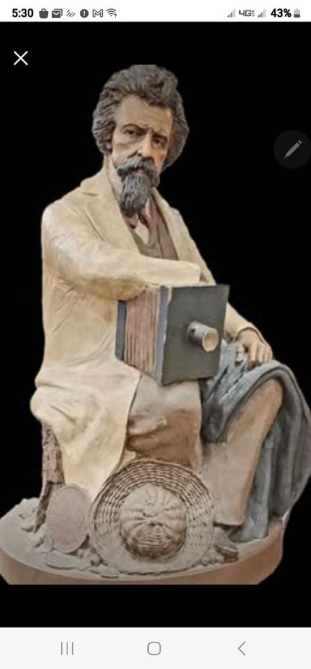 Collectible ceramic sculpture by Tom Clark of Mathew Brady famous Civil War photographer. Circa 1991: This is a vintage ceramic sculpture of Mathew Brady, a famous Civil War photographer, created by artist, Tom Clark in 1991. It depicts Brady resting on a tree stump, with his camera and straw hat