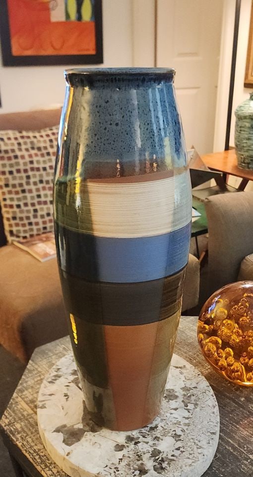 Stunning 21h hand-thown ceramic art vase w/ bold striped design & great shadow illusion. Signed 2022: Can you see the shadow that isn't there? This modernist striped vase is a stylish addition to any room. The vase has a glazed ceramic finish and is adorned with blue, brown and reddish-brown bands.