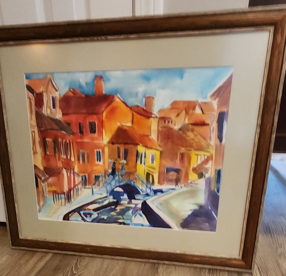 Betty Hall Risner.. Vintage watercolor painting of Venice Italy with canals. Framed under non-glare: This watercolor painting presents a scenic European-inspired scene of Venice Italy, featuring canals and historic buildings. Two figures are depicted standing under umbrellas on a bridge. Reserve: $30