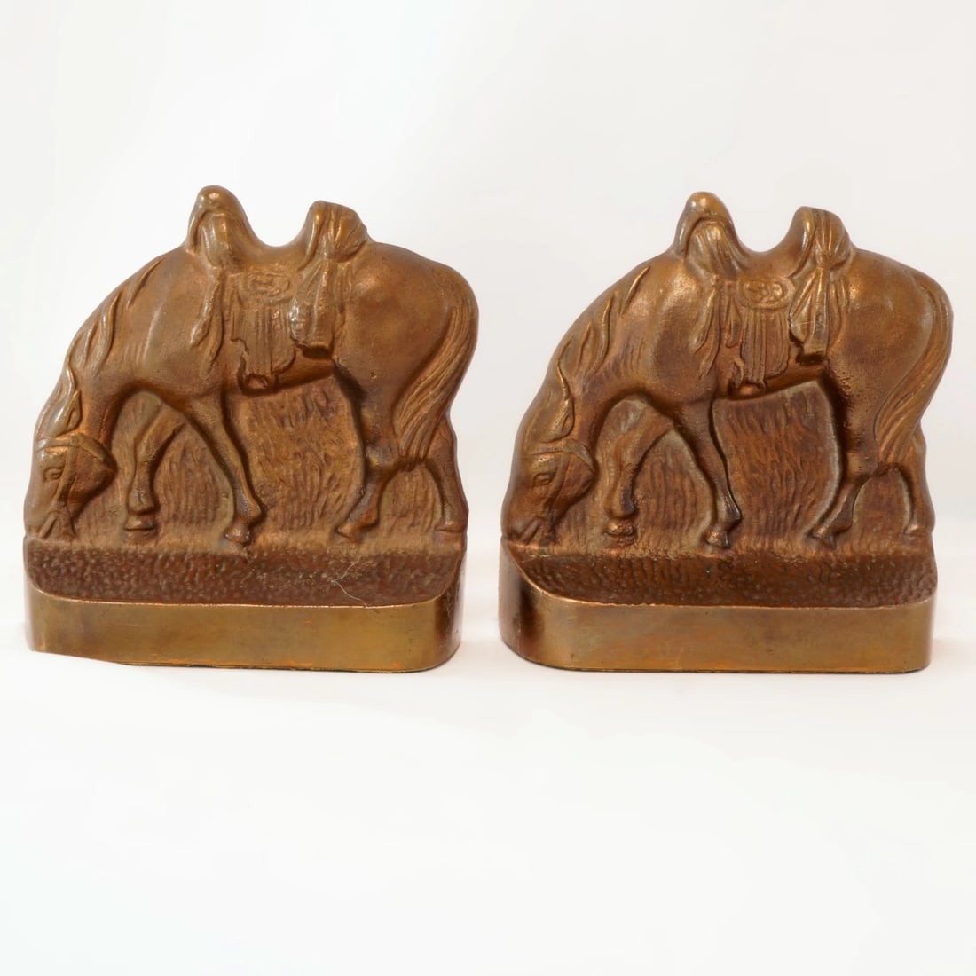 Pair 1930s Riderless Horse Bookends: Title:Pair 1930s Riderless Horse Bookends Size:4 in (10.2 cm) wide x 4 1/8 in (10.5 cm) tall x 1 ¼ in (3.2 cm) deep. Description:A pair of cast iron bookends of horses with their heads lowered 