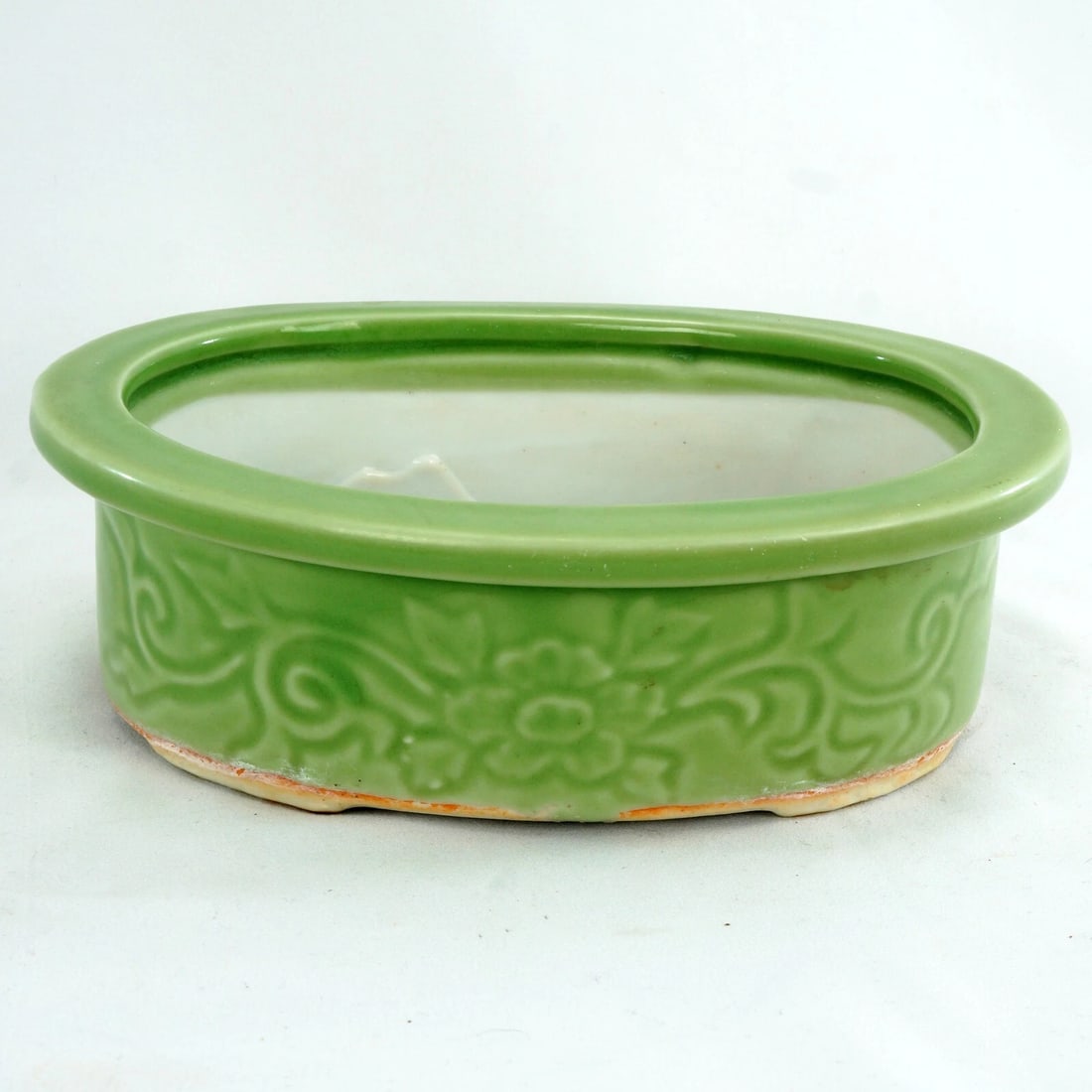 Japanese Celadon Footed Bulb Pot 1920's/30's: Title:Japanese Celadon Footed Bulb Pot 1920's/30's Size:8 in (20.3 cm) long x 6 3/8 in (16.0 cm) wide x 2 ½ in (6.4 cm) tall. Description:An oval Japanese bulb pot with a white interior and cel