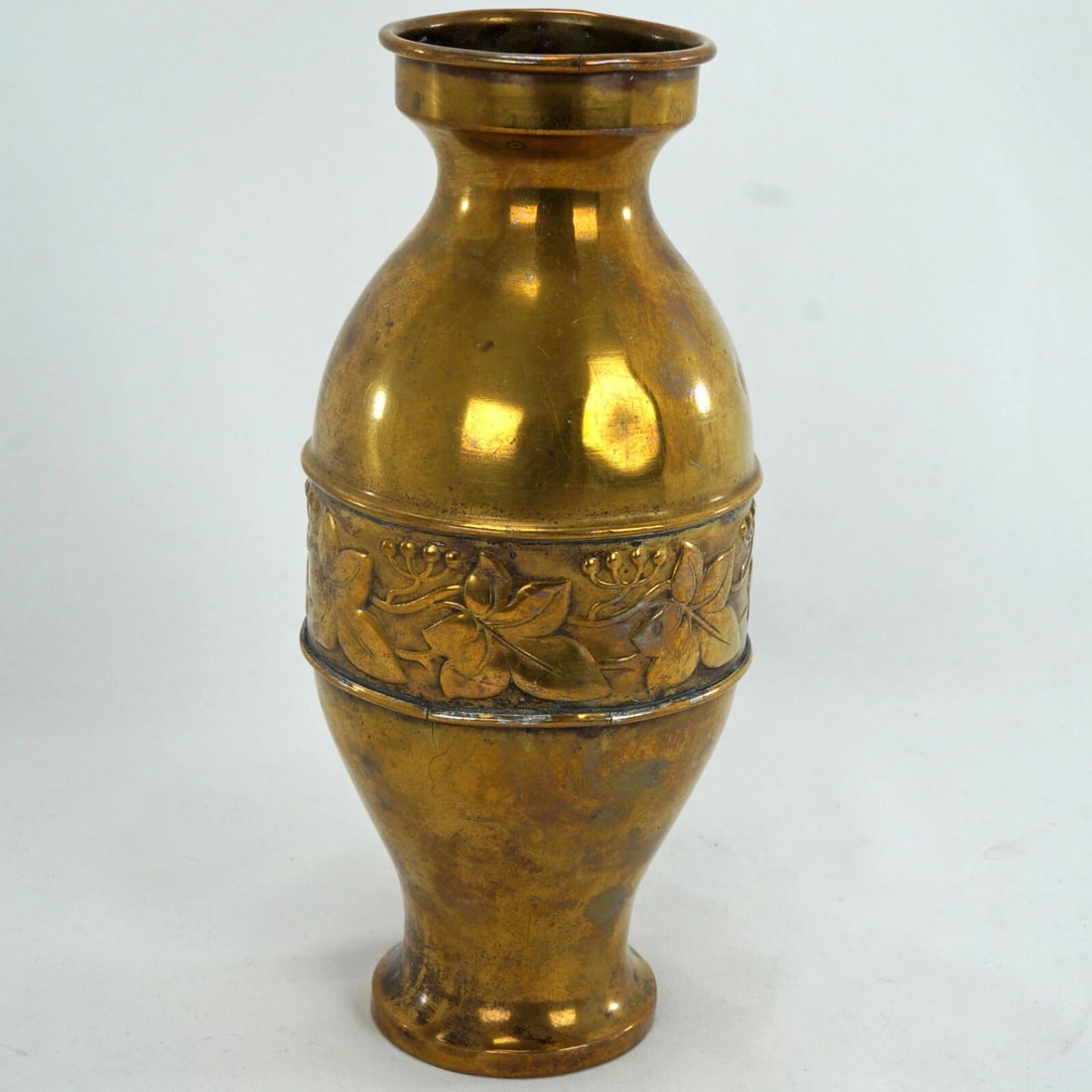 1930s Art Deco Farberware Brass Vase: Title:1930s Art Deco Farberware Brass Vase Size:3 ¼ in (8.3 cm) diameter x 7 ½ in (19.0 cm) tall. Description:A shiny brass vase with an Art Deco decorated band with leaves and fruit. Th