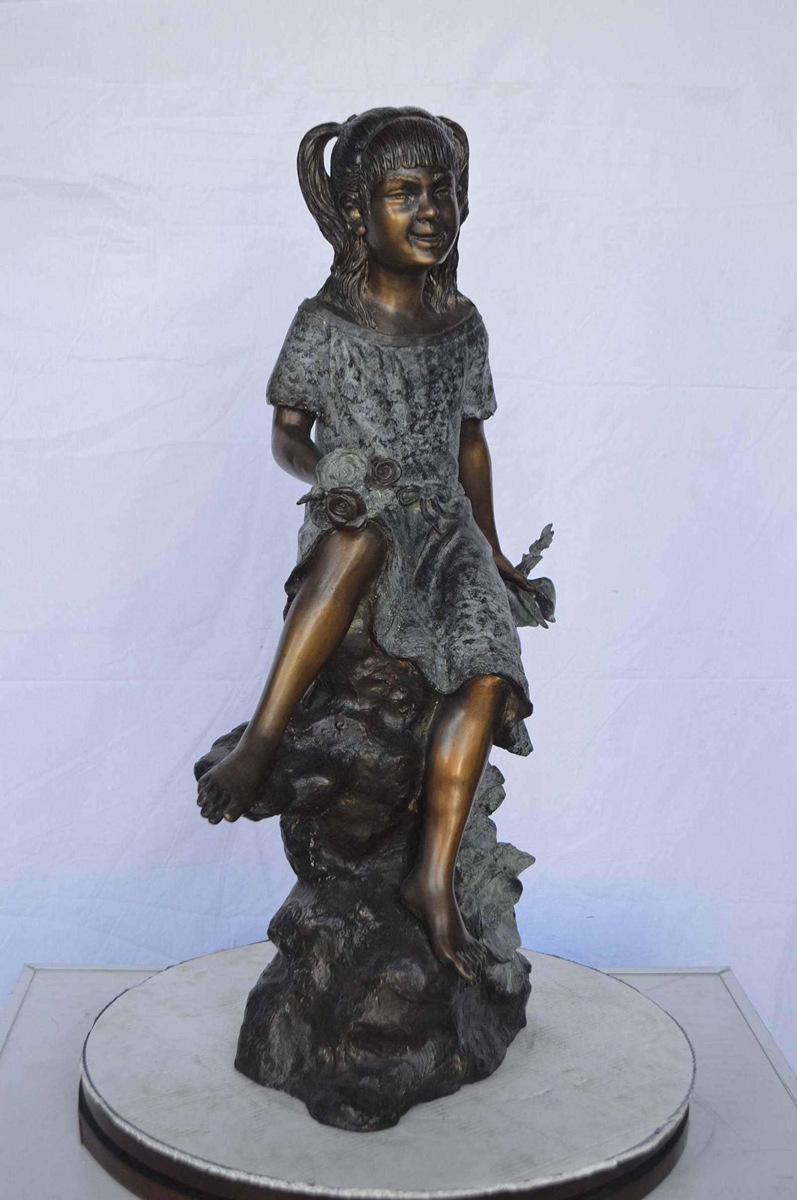 Girl on Tree Trunk Holding Flowers Bronze Statue - Size: 26"L x 11"W x 36"H. - 3