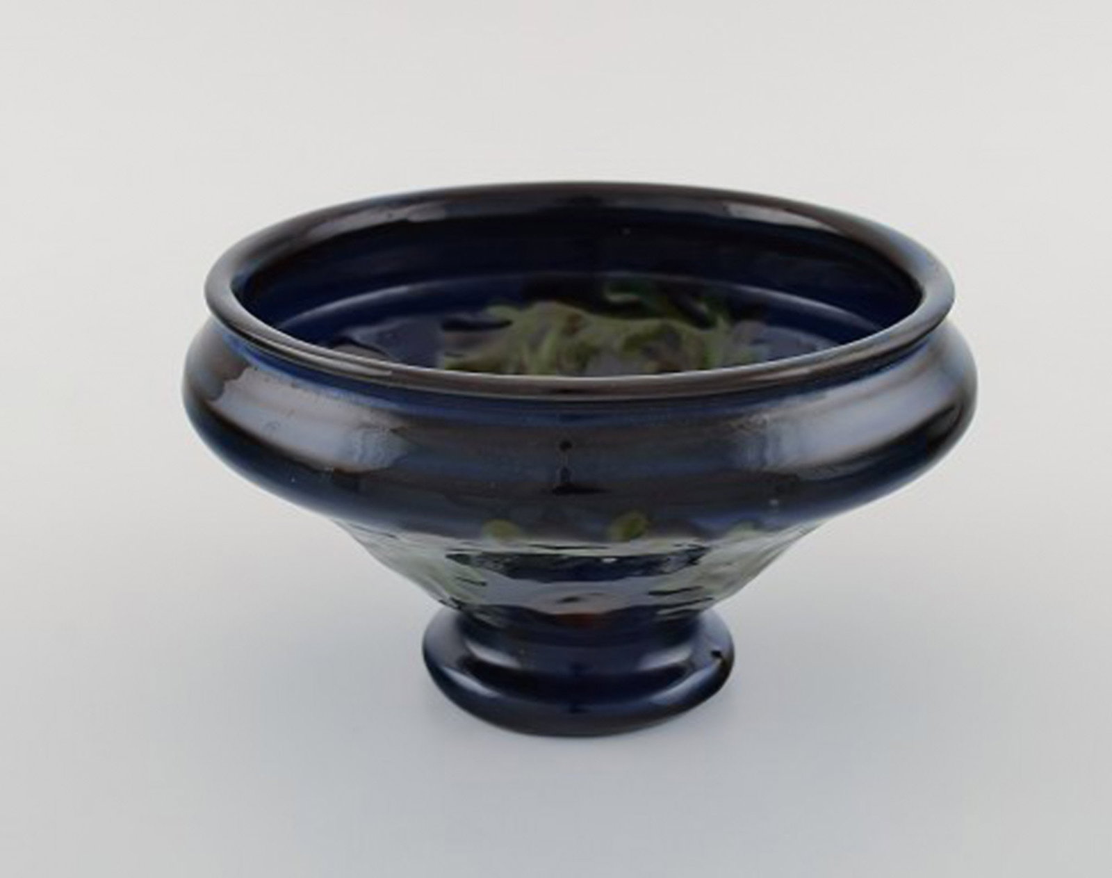 Kahler, Denmark. Bowl in glazed ceramics. Green leaves and red berries on a dark blue background. - 3