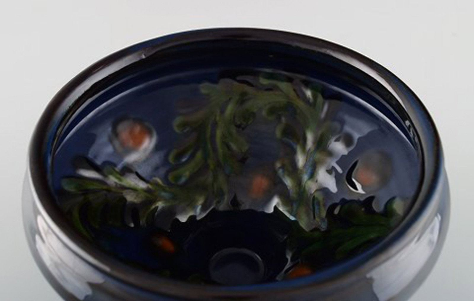 Kahler, Denmark. Bowl in glazed ceramics. Green leaves and red berries on a dark blue background. - 5
