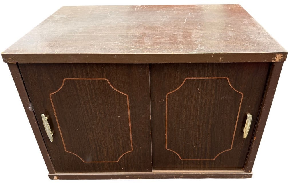 Mid-Century Modern Dark Wood Sliding Door Cabinet: This mid-century modern cabinet features a dark wood finish with two sliding doors, each adorned with a decorative geometric border within the panel. The cabinet is likely constructed from particle