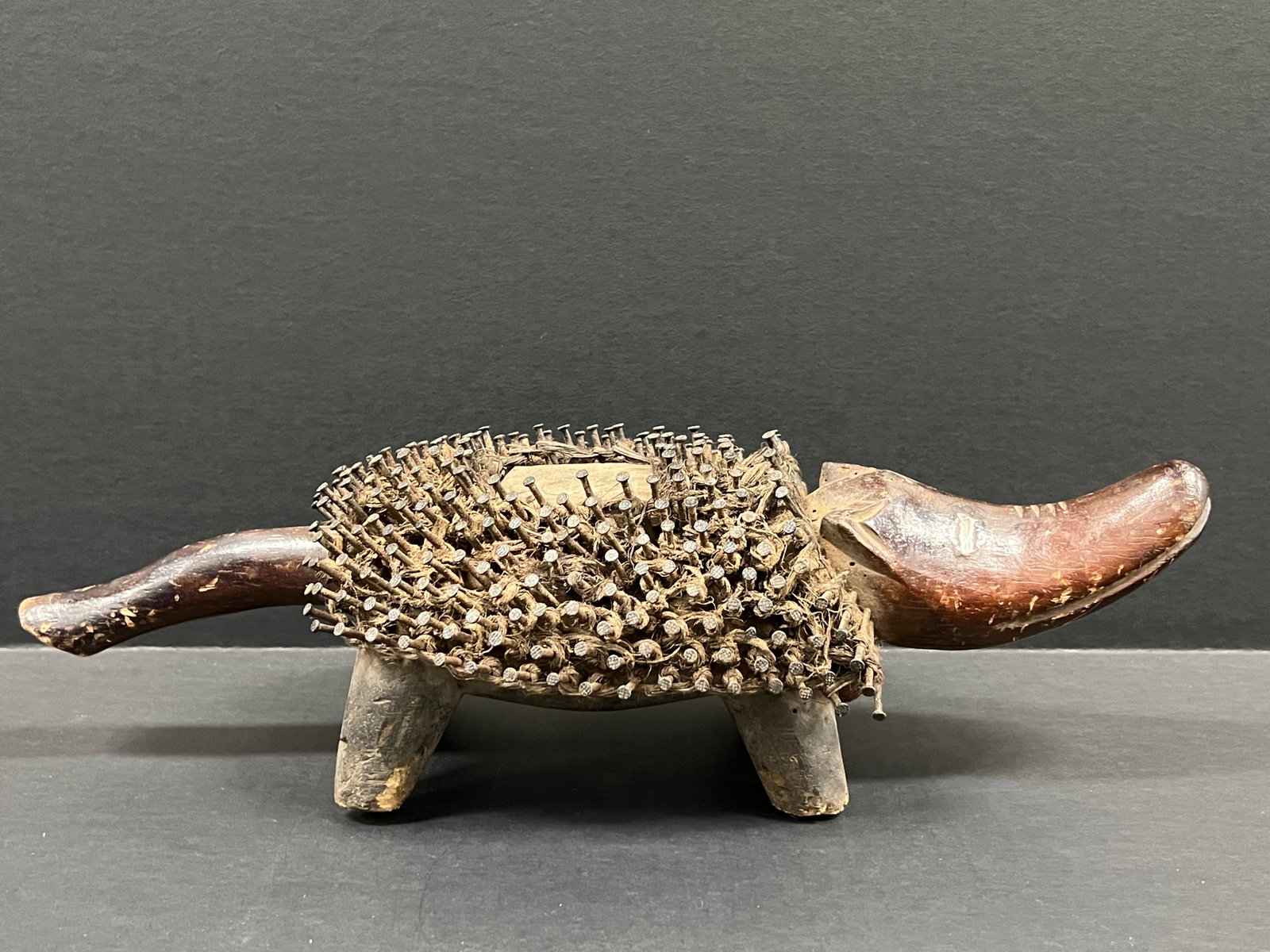 African Tribal Art Carved Wood Bacongo Nail Fetish Dog: Title: Bacongo Nail Fetish Dog Date/Period: Late 20th Century Materials: Wood Size: 5" h x 16.5" w Reserve: $100.00 Shipping: Domestic: Flat-rate of $40.00 to anywhere within the contiguous U.S.