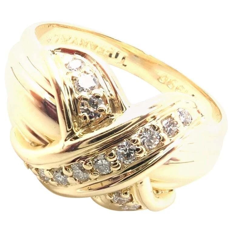 Authentic! Tiffany & Co 18k Yellow Gold Diamond Signature X Band Ring: Authentic! Tiffany & Co 18k Yellow Gold Diamond Signature X Band Ring About This Piece: Metal: 18k Yellow Gold Ring Size: 5 3/4 Weight: Width: 6.9 grams 10mm Stones: 14 Round Brilliant Cut Diamonds
