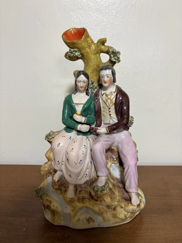 Staffordshire Man & Woman Figural Spill Vase: It measures 11 7/8" x 7" x 3 3/4" and dates around the 1880's. It has a small flake on one foot, two chips and a flaw on the top of the vase. Otherwise it has no other issues. Overall it is in good