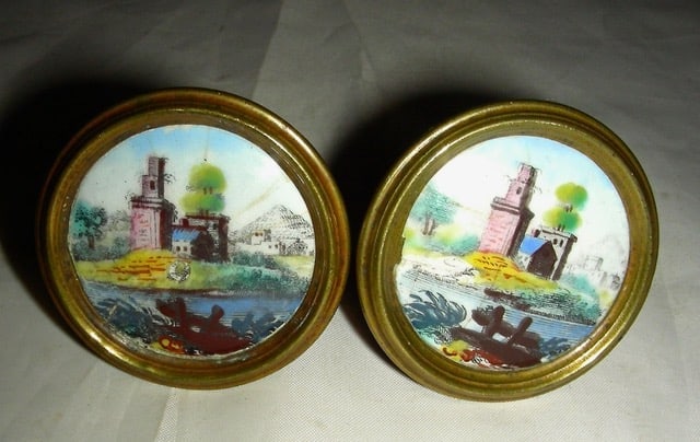 Pr. Battersea Enamel Mirror Supports c.1800: A pair of early 19th century (c. 1800 or a bit earlier) Battersea Enamel Mirror Supports (or posts), used to provide support for mirrors hung on the wall. Both show a similar (as similar as 2