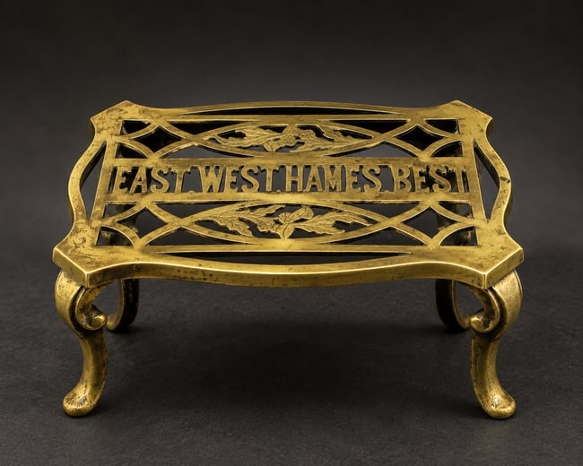 Victorian Solid Brass Footman Stand "East West Hame's Best" Scottish Motto: Date/Period: Circa 1890-1910 Dimension: Approx. 6.5" tall x 18" x 8.5" weighs 7 pounds Material: brass Additional Information: Antique Victorian brass footman trivet featuring the beloved Scottish