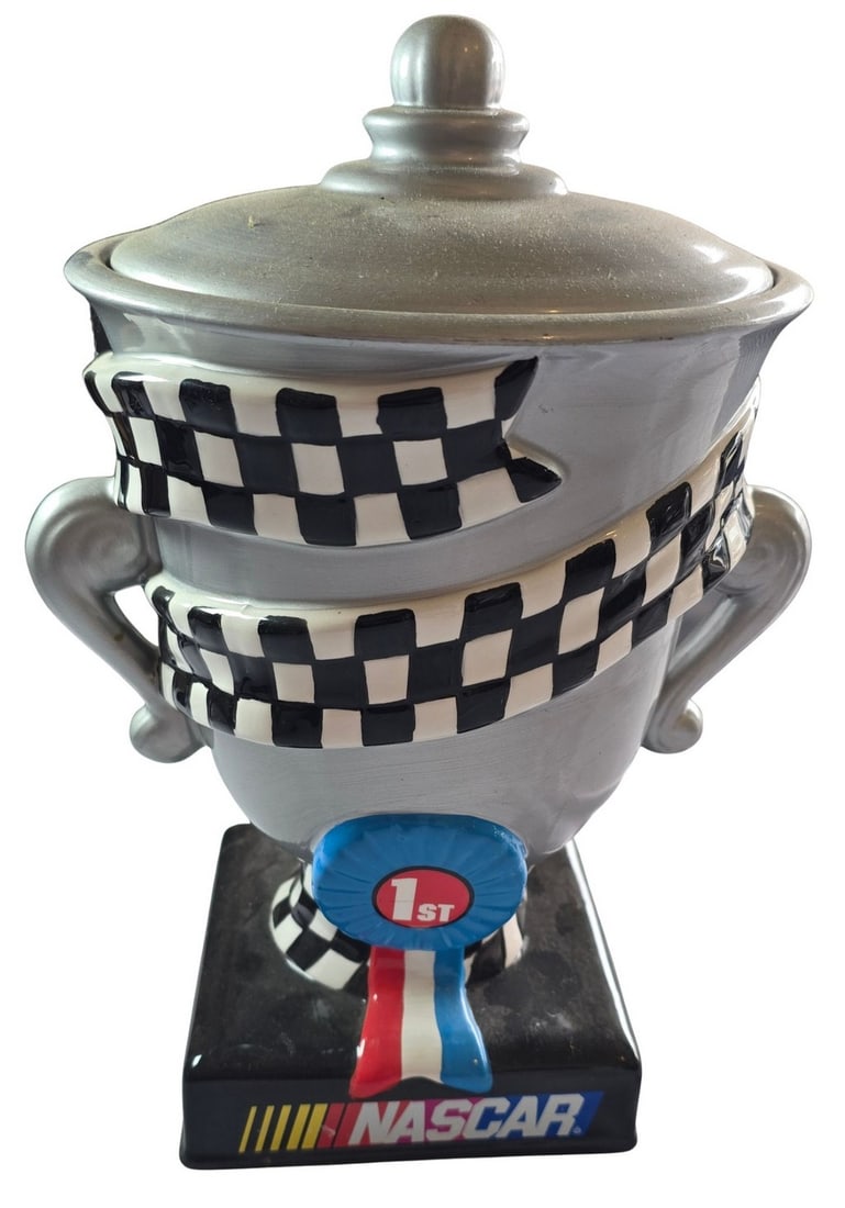 2002 NASCAR Gibson Ceramic Lidded Trophy Jar: This 2002 NASCAR branded ceramic lidded jar, manufactured by Gibson, takes the form of a racing trophy. The jar features a silver-tone finish with a black and white checkered flag design wrapping arou