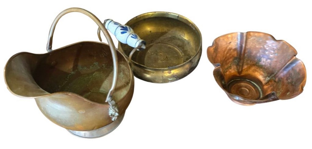 Three Pieces of Vintage Metal Decor: Copper Coal Scuttle, Brass Bowl, and Florentine Copper Bowl: This lot features three distinctive pieces of vintage metal decor. The first is a charming copper coal scuttle or hod, distinguished by a white ceramic handle adorned with blue floral motifs. The scut