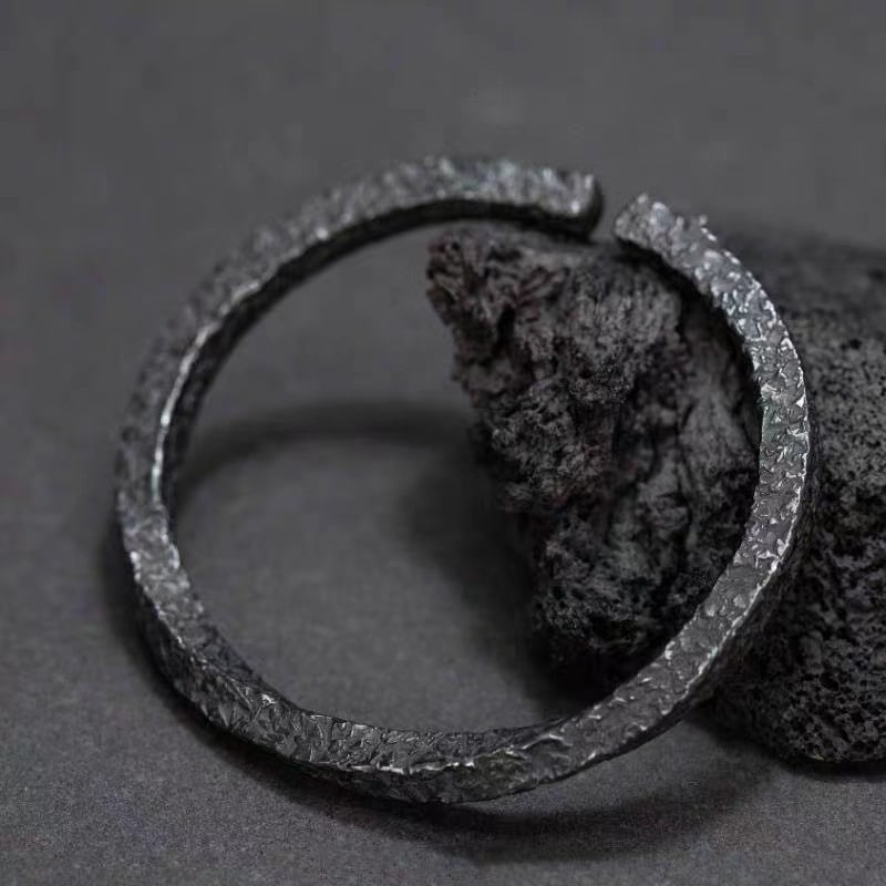 Forged Midnight Bangle - Textured Titanium Steel Adjustable: Title: Forged Midnight Bangle - Textured Titanium Steel Adjustable Description:Crafted from durable titanium steel, this bangle features a rugged hammered texture. Its open-ended, adjustable design of