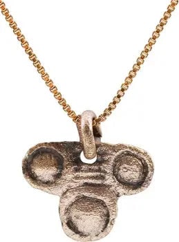 ITALIAN WOMAN'S PENDANT, C. 1450-1650: Gilt bronze, under 5/8" width. formed as three concentric circles with domed or hemispherical centers. This form is thought to derive from the Medici family coat of arms. The original symbol for pawn 