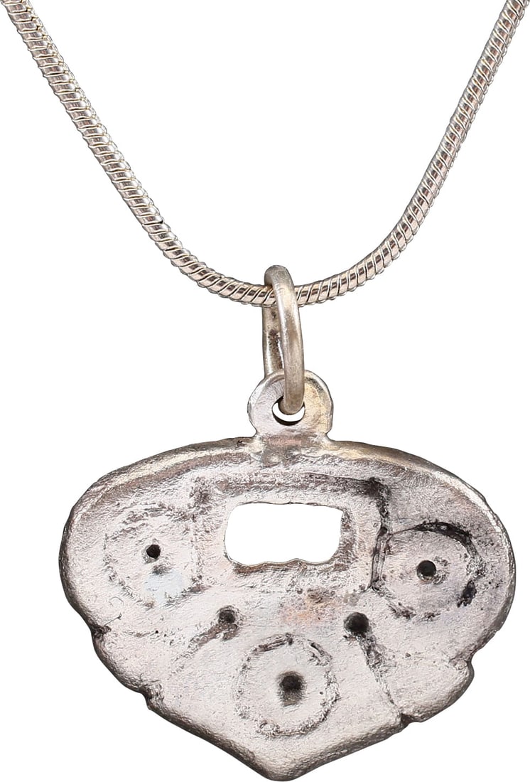 GOOD VIKING HEART PENDANT 9th-10th CENTURY AD: Broad, full, rounded edge flat section, of transitional form. 7/8" width with pierced rectangle surrounded by three " circle and dot" motifs. Surely of spiritual/mystical significance, now lost. For V