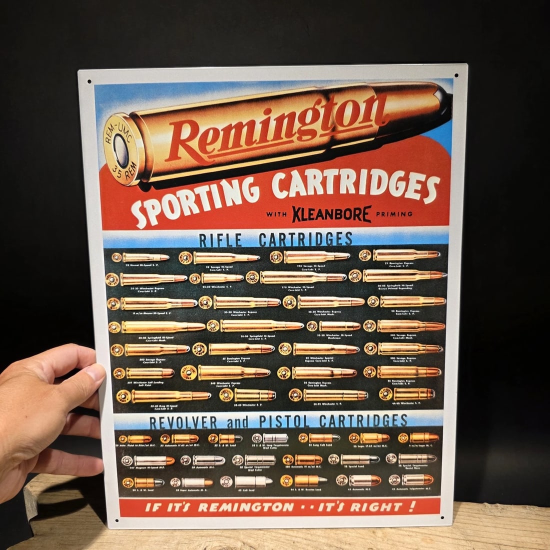 Remington Sporting Cartridges Tin Sign – Rifle Pistol Ammunition Advertising: 16" x 12 1/2" Reproduction Remington Sporting Cartridges advertising sign featuring a slightly blurry display of rifle, revolver, and pistol cartridge types, styled after early 20th-century
