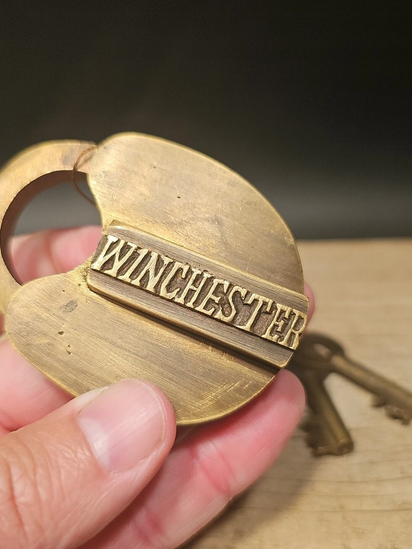 Brass Winchester Firearms Ammo Box Padlock Lock & Key: 3" tall x 2 1/4" Wide Nice reproduction cast iron winchester padlock! This lock is fully functional! Hard to tell its age. Heavy iron and brass. Great aged patina throughout. Limited quantity availabl