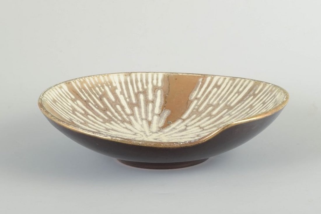 Scandinavian studio pottery. Wheel-thrown stoneware bowl with organic form. Ca. 1960/70s.: Scandinavian Studio Pottery Bowl, c. 1960/70s. Wheel-thrown stoneware bowl with organic form. Interior decorated with radiating white and golden glaze pattern on a light brown base. Exterior with