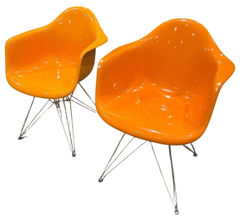 Pair of Mid-Century Modern Orange Fiberglass Armchairs with Wire Bases after Herman Miller: A striking pair of Mid-Century Modern armchairs, featuring vibrant orange fiberglass shells and iconic wire "Eiffel Tower" bases. These chairs, resembling those designed by Charles and Ray Eames, are 