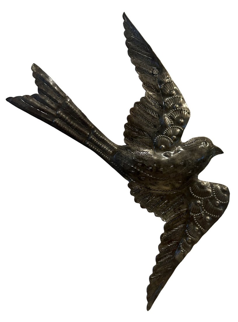 Hand-hammered Metal Folk Art Bird Wall Hanging: This charming folk art wall hanging depicts a bird in flight, crafted from hand-hammered metal. The bird features detailed wings and tail feathers with a textured, almost scaly appearance, indicative