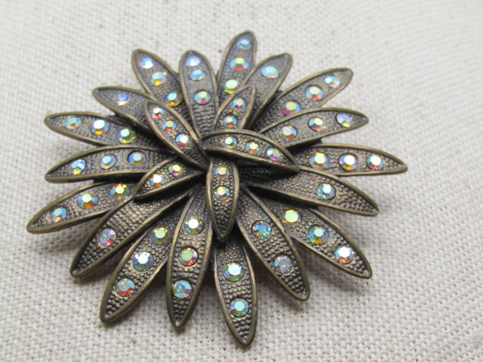 Vintage AB Rhinestone Blossom/Starburst Brooch, 2.25" 1960's-1970's: Title: Vintage AB Rhinestone Blossom/Starburst Brooch, 2.25" 1960's-1970's Description: Vintage AB Rhinestone Blossom or Starburst Brooch, 2.25" 1960's-1970's. Brassy gold tone with pointed petals, lo