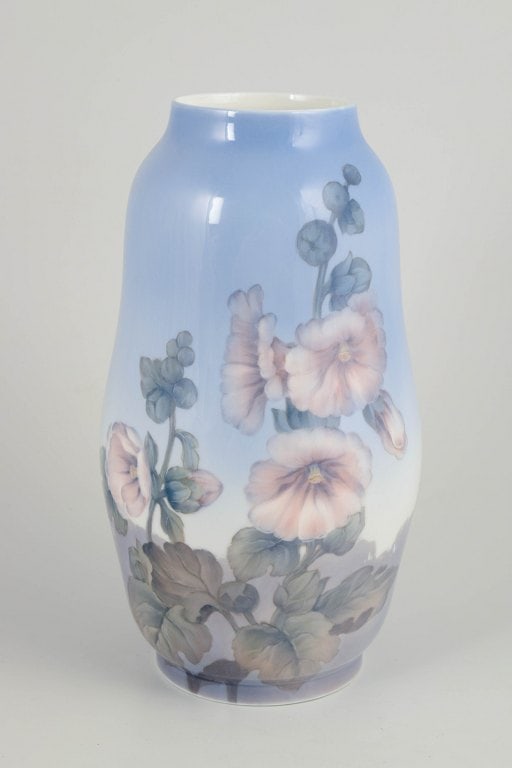 Royal Copenhagen, Denmark. Large baluster-shaped porcelain vase decorated with flowers and foliage: Royal Copenhagen, vase. Large baluster-shaped porcelain vase with a hand-painted underglaze decoration of flowers and foliage in soft pink, green, and grey tones against a pale blue ground. The decora