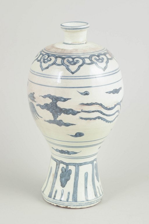 China. Baluster-form porcelain vase decorated in underglaze blue. Late Ming dynasty.: China, vase. Late Ming dynasty. Baluster-form porcelain vase with a waisted neck and spreading foot, decorated in underglaze blue. The decoration depicts a phoenix (fenghuang) flying among stylised