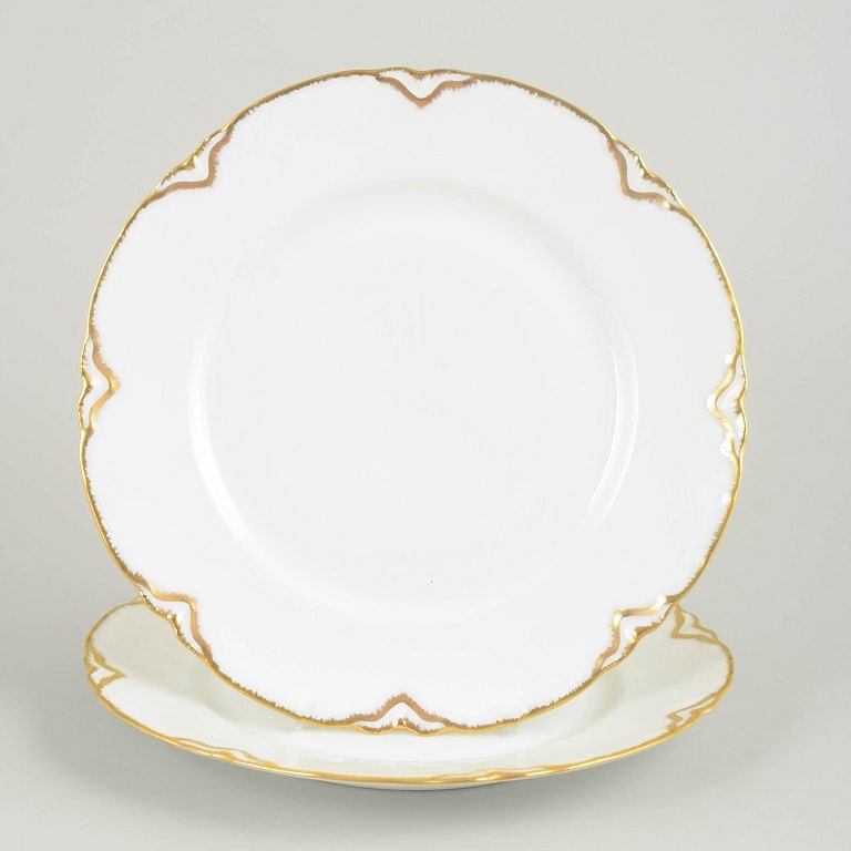 Haviland/Limoges, France. Set of two porcelain dinner plates with a scalloped rim. Approx. 1930s.: Haviland/Limoges, set of two porcelain dinner plates. Two French white faience dinner plates with a scalloped rim, gilt edge and stylised Art Deco-inspired gold detailing around the border. Origin: Fr