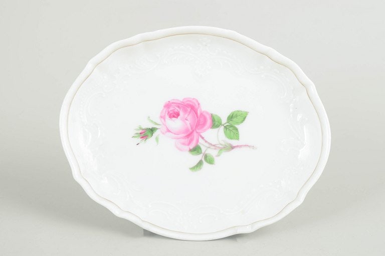 Meissen, Germany. Small porcelain dish with polychrome rose in the centre. Approx. 1930s–1940s.: Meissen, small dish. Small oval dish in hard-paste porcelain decorated with a hand-painted pink rose to the centre, framed by subtle moulded relief along the rim. A refined Meissen example with clear