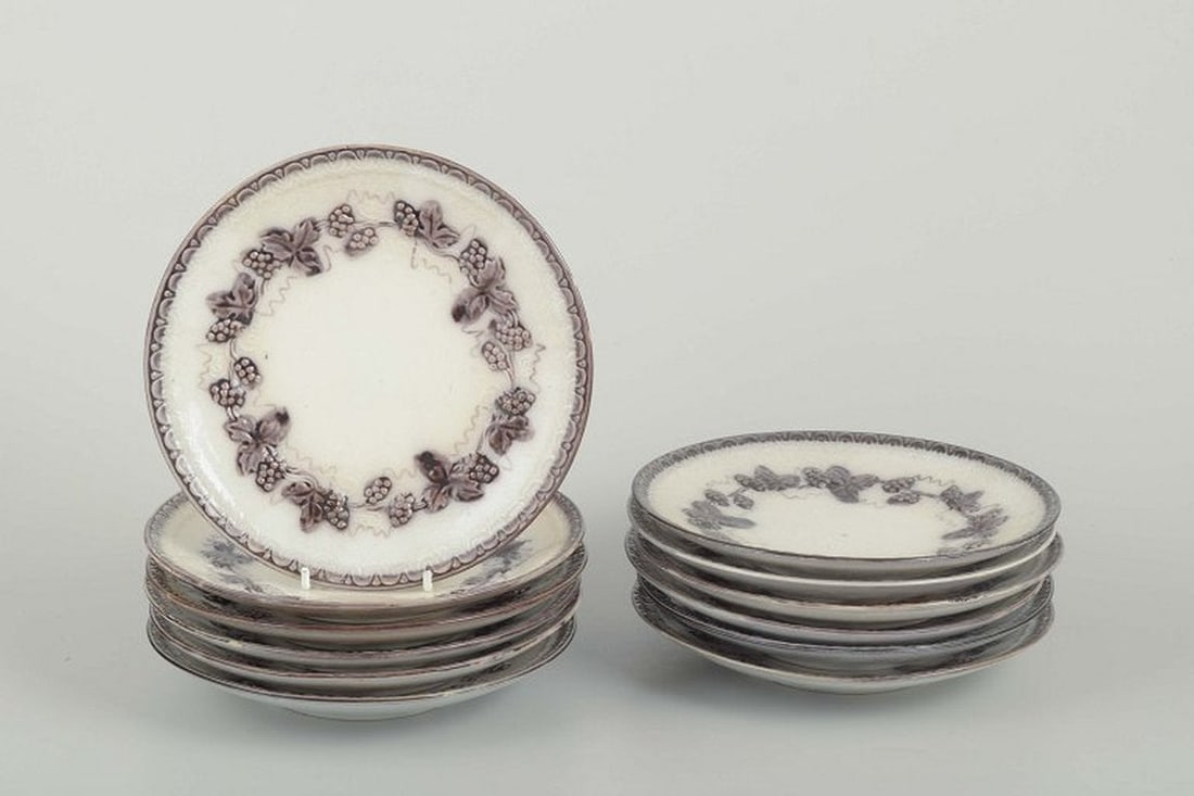 Gefle, Sweden. Set of twelve round 'Mullbär' faience plates with relief decoration. 1930s.: Gefle Plates “Mullbär”, 1930s Set of 12 round faience plates with relief decoration and grapevine motif in a brownish tone along the rim. Maker: Gefle Pattern: “Mullbär” Material: