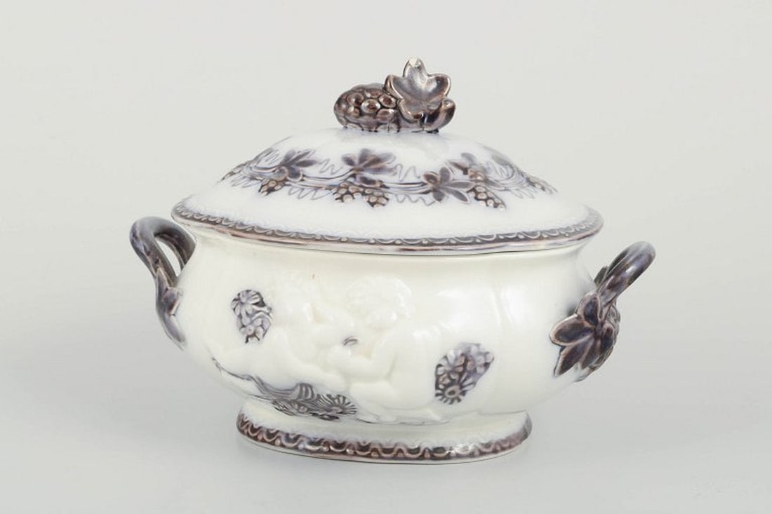 Gefle, Sweden. Oval 'Mullbär' faience tureen with relief decoration. Ca. 1880/90s.: Gefle Tureen “Mullbär”, c. 1880/90s. Oval faience tureen with lid, shaped with double handles and a knop modelled as a grape cluster with leaf. Decorated in relief and transfer print with vin