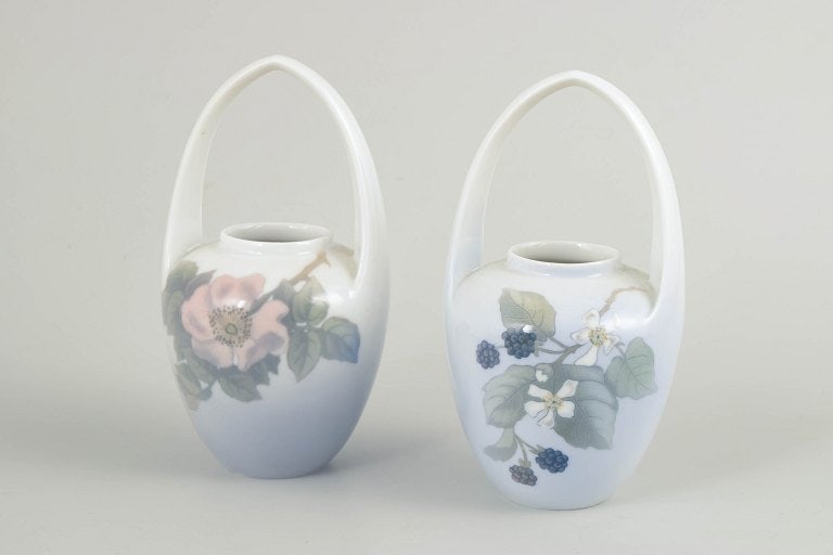 Royal Copenhagen, Denmark. Art Nouveau, set of two porcelain vases with handles. Circa 1910s.: Royal Copenhagen, Art Nouveau vases with handles, set of 2. Set comprising two vases in glazed porcelain with integrated handles and hand-painted underglaze decoration in Art Nouveau style. The decora