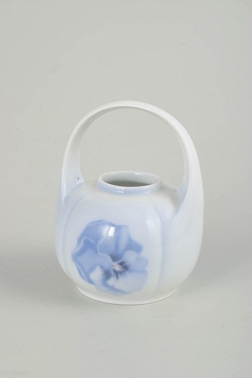 Royal Copenhagen, Denmark. Art Nouveau porcelain vase with handle with floral motif. Approx. 1900s.: Royal Copenhagen, Art Nouveau vase with handle. Porcelain vase with integrated handle and hand-painted underglaze decoration in Art Nouveau style, featuring a stylised floral motif in soft blue tones.