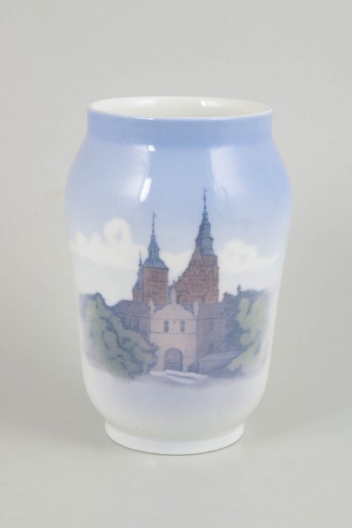 Royal Copenhagen, Denmark. Porcelain vase with Rosenborg Castle motif in blue, green and brown: Royal Copenhagen, vase with Rosenborg Castle motif. Glazed porcelain vase with hand-painted underglaze decoration depicting Rosenborg Castle, with towers and surrounding landscape rendered in soft
