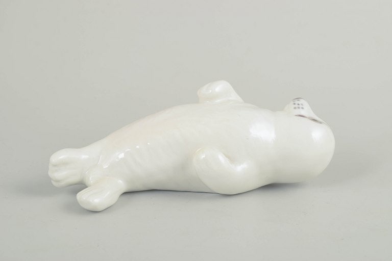 Royal Copenhagen, Denmark. Porcelain baby seal figurine with soft, rounded forms. Approx. 1990s.: Royal Copenhagen, baby seal figurine. Porcelain figurine depicting a reclining baby seal, modelled with soft, rounded forms and finished in a uniform white glaze that emphasises the calm,