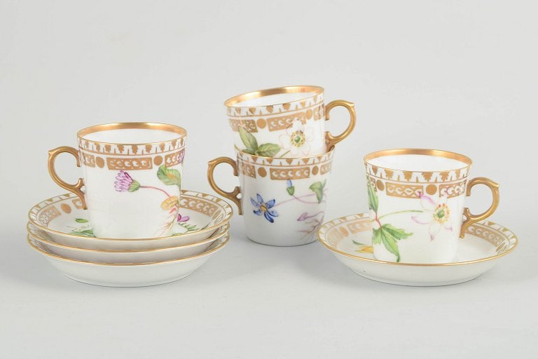 Royal Copenhagen, Denmark. Flora Danica set of four porcelain cups with matching saucers. Circa: Royal Copenhagen, set of 4 demitasse cups with matching saucers. Porcelain in Flora Danica style with hand-painted botanical motifs and gilt rims. Origin: Denmark. Material: Porcelain. Dimensions: Cup