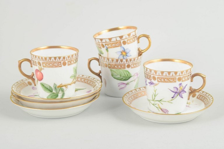 Royal Copenhagen, Denmark. Flora Danica set of four porcelain cups with matching saucers. Dated: Royal Copenhagen, set of 4 demitasse cups with matching saucers. Porcelain in Flora Danica style with hand-painted botanical motifs and gilt rims. Origin: Denmark. Material: Porcelain. Dimensions: