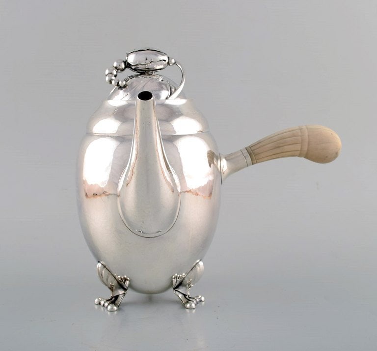 Early Georg Jensen Magnolia coffee pot in sterling silver with handle in ivory. Model number 2D.: Title:Early Georg Jensen Magnolia coffee pot in sterling silver with handle in ivory. Model number 2D. 1920's. Description:Early Georg Jensen Magnolia coffee pot in sterling silver with handle in
