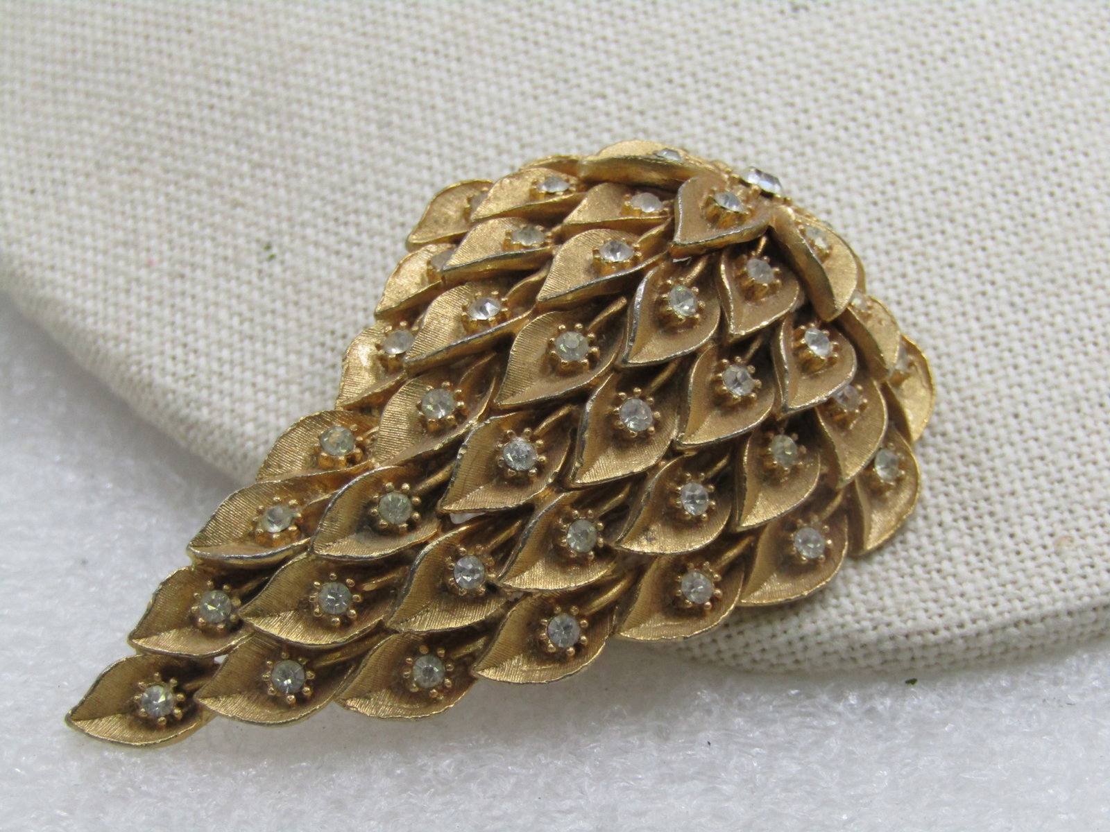 Vintage Gold Tone Rhinestone Strawberry Like Brooch, 2.5": Vintage Gold Tone Rhinestone Strawberry Like Brooch, 2.5" by 1.5". It has an exaggerated strawberry shape, a bit mod for it's mid-century age and in each section is a single clear rhinestone - like