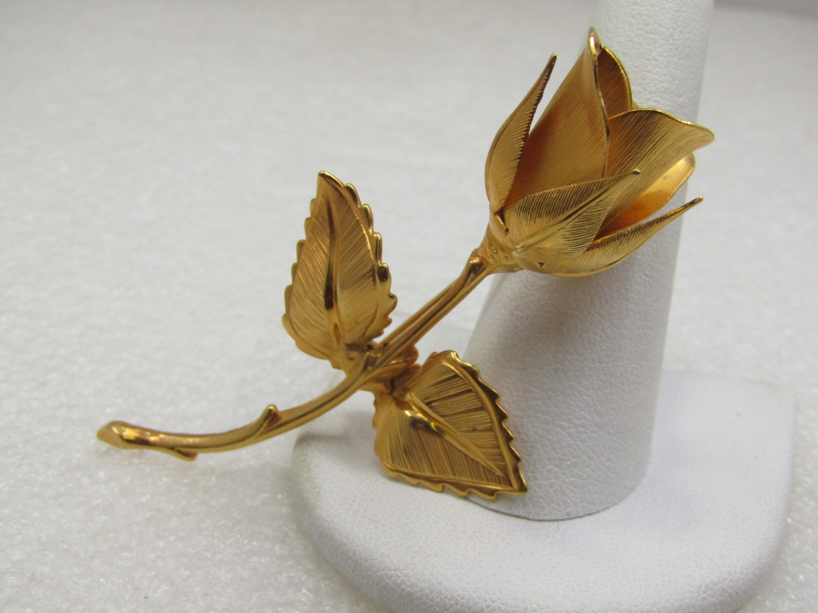 Vintage Long Stem Rose Brooch, Gold Tone 2.75", 1960's: Vintage Long Stem Rose Brooch, Gold Tone 2.75", 1960's. 1-5/8" wide at the two textured leaves. 3/4" wide at the textured 3-d rose blossom. Curved stem - a mix of mooth and shiny and textured finish. 